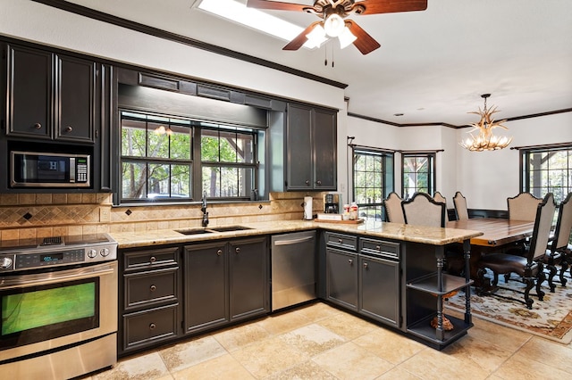 kitchen featuring sink, light stone countertops, appliances with stainless steel finishes, decorative light fixtures, and kitchen peninsula