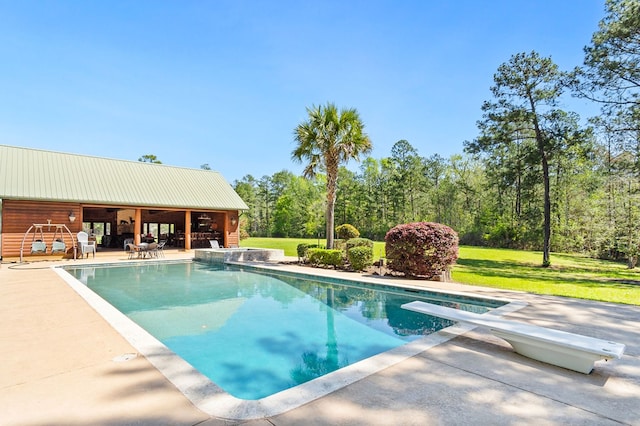 view of pool featuring an outdoor structure, a diving board, a patio area, and a lawn