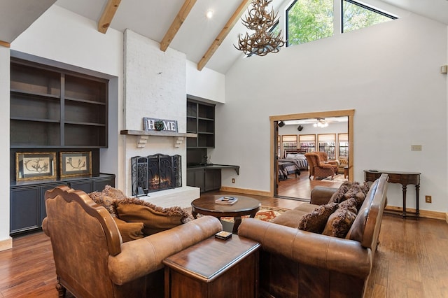 living room with ceiling fan with notable chandelier, beam ceiling, high vaulted ceiling, a fireplace, and dark hardwood / wood-style floors