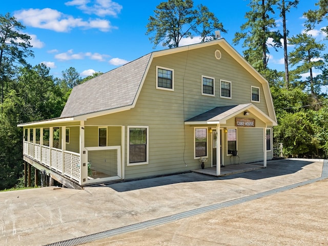 264 Wildbriar Dr, Jasper, TX 75951 - colonial inspired home with a porch, a gambrel roof, roof with shingles, and driveway
