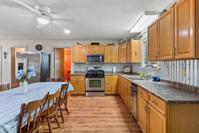 264 Wildbriar Dr, Jasper, TX 75951 - kitchen with appliances with stainless steel finishes, a sink, light wood-type flooring, dark countertops, and a ceiling fan