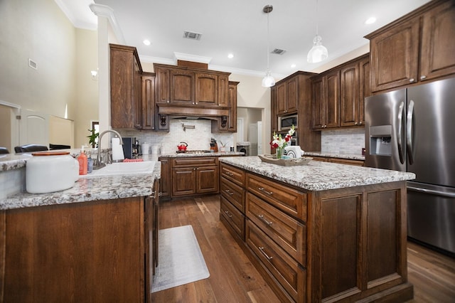 kitchen with stainless steel appliances, visible vents, a sink, and crown molding