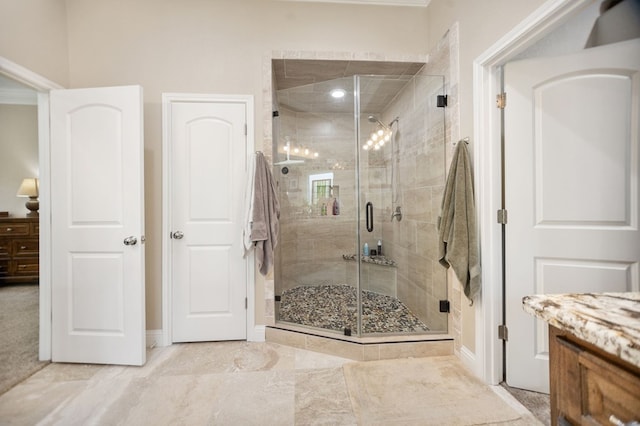 bathroom with baseboards, vanity, and a stall shower