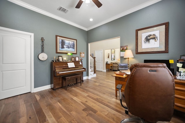 office space with visible vents, baseboards, wood finished floors, ceiling fan, and ornamental molding