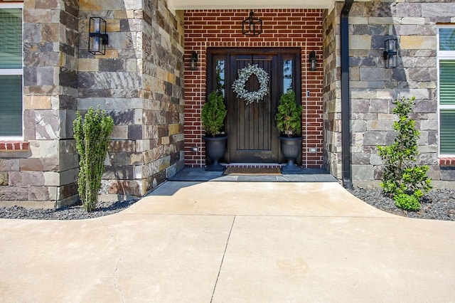 doorway to property with stone siding and brick siding