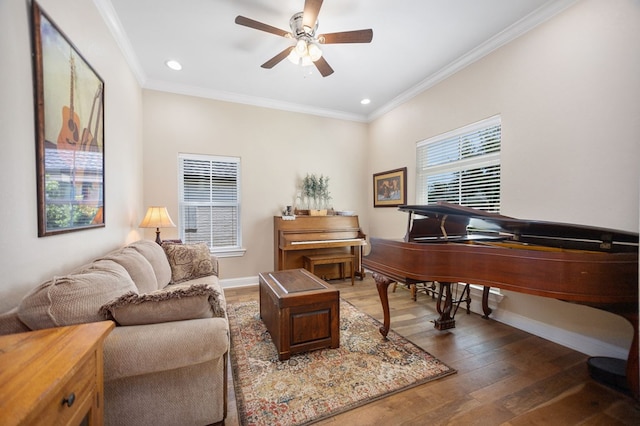 living area with crown molding, a ceiling fan, wood finished floors, baseboards, and recessed lighting