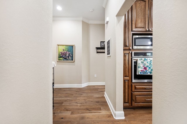 corridor with baseboards, ornamental molding, dark wood-style floors, and recessed lighting