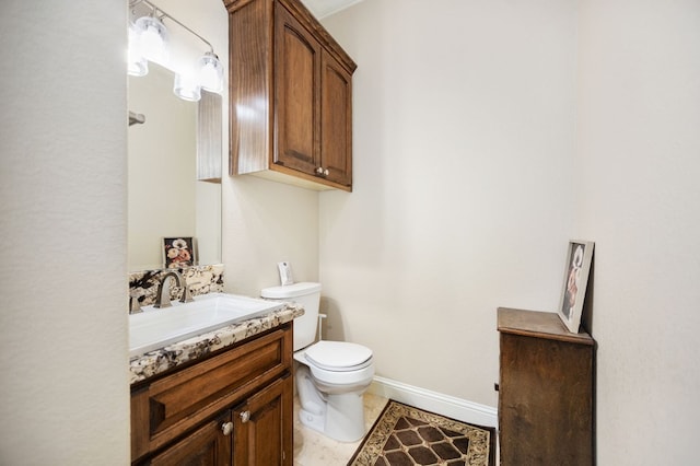 bathroom featuring baseboards, vanity, and toilet