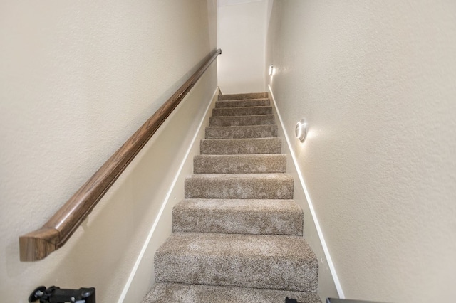staircase featuring a textured wall
