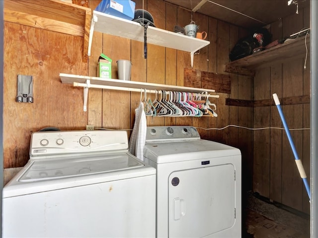 laundry area featuring wood walls, washing machine and clothes dryer, and laundry area