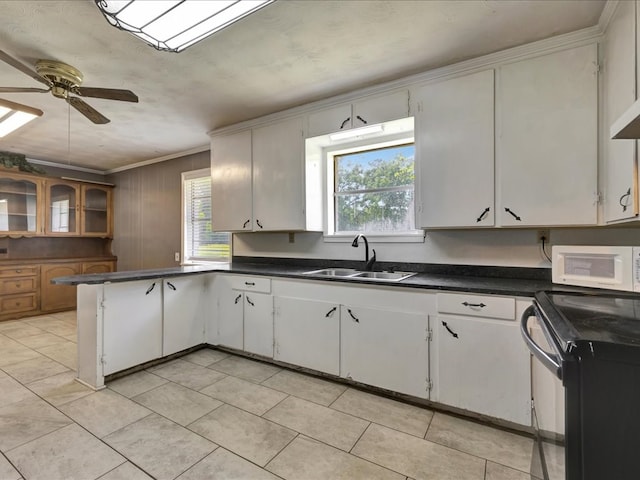 kitchen featuring a sink, ceiling fan, white microwave, a peninsula, and black electric range
