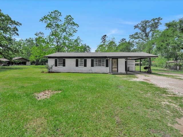 ranch-style house featuring driveway, an attached carport, and a front lawn
