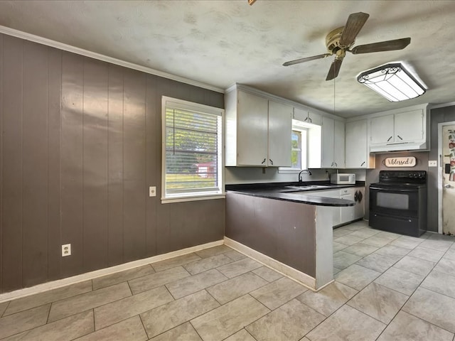 kitchen with ceiling fan, a peninsula, ornamental molding, dark countertops, and electric range