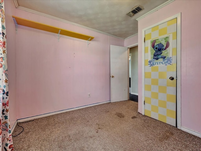 unfurnished bedroom with carpet flooring, crown molding, and visible vents