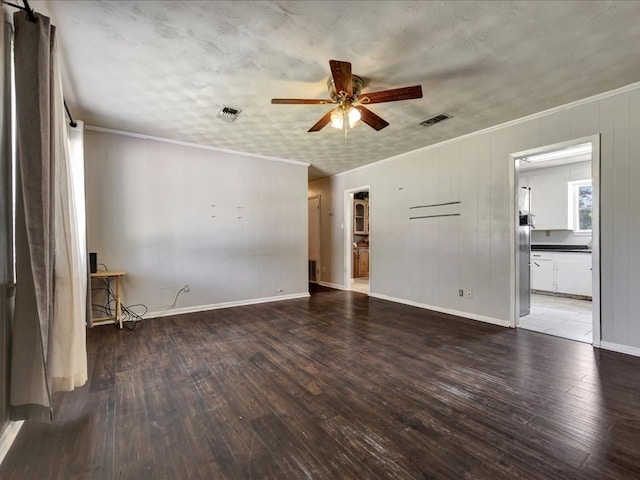 unfurnished living room featuring visible vents, wood finished floors, a ceiling fan, and crown molding