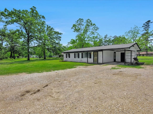 view of front facade with driveway, a carport, and a front lawn