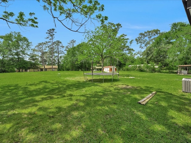 view of yard with cooling unit and a trampoline