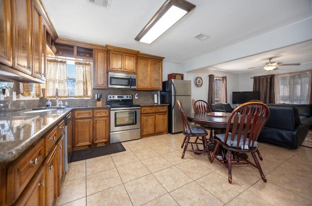 kitchen featuring tasteful backsplash, stainless steel appliances, ceiling fan, sink, and light tile patterned floors