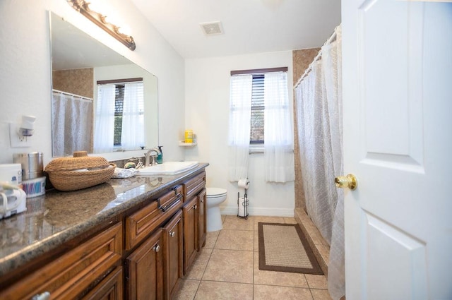 bathroom featuring tile patterned floors, vanity, toilet, and a wealth of natural light