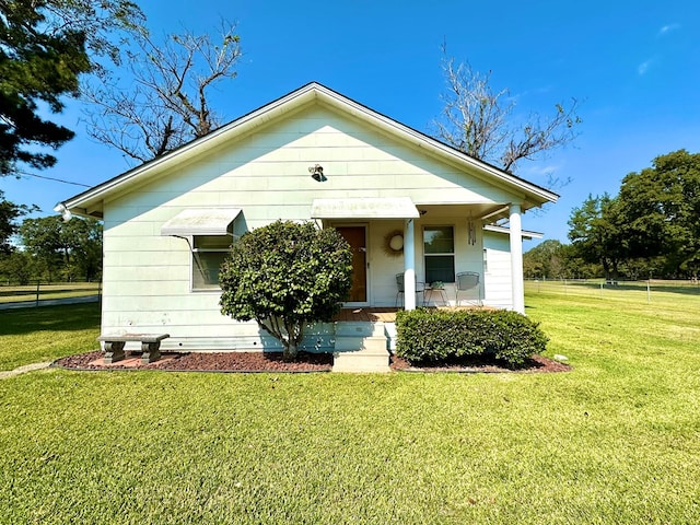 bungalow featuring a porch and a front lawn