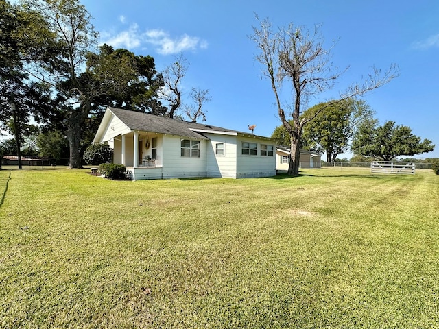 exterior space featuring covered porch and a yard