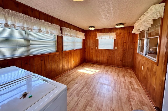 unfurnished sunroom featuring independent washer and dryer