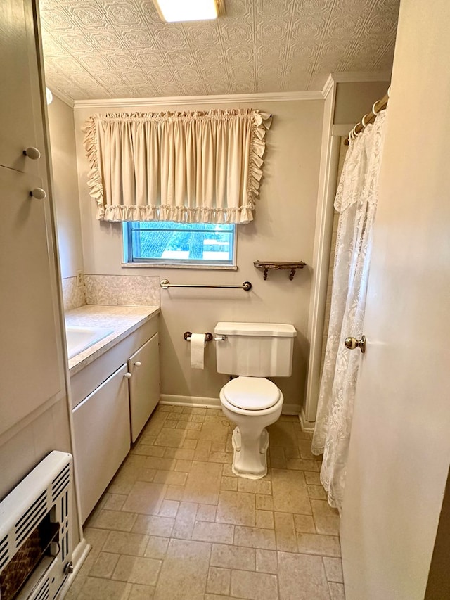 bathroom with vanity, toilet, crown molding, and heating unit