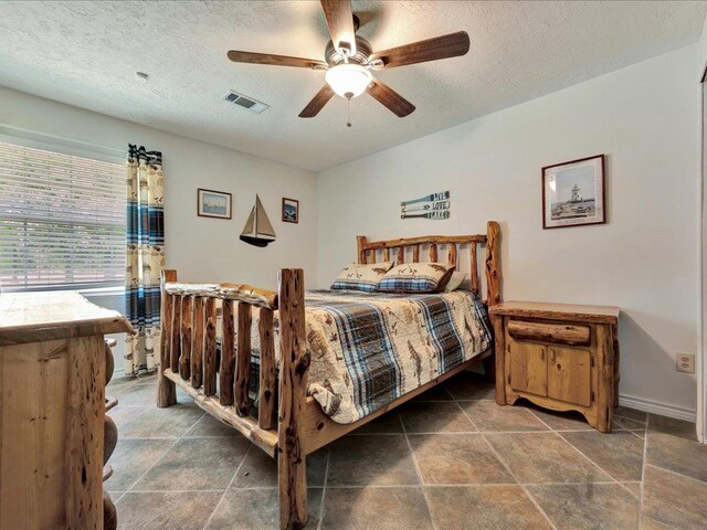 21441 Fm 705, Broaddus, TX 75929 - bedroom with a textured ceiling, ceiling fan, and baseboards