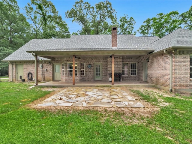 7830 Fm 3150, Lufkin, TX 75904 - back of property with brick siding, a chimney, a shingled roof, a lawn, and a patio area
