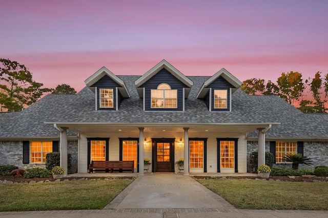 new england style home with a yard and covered porch