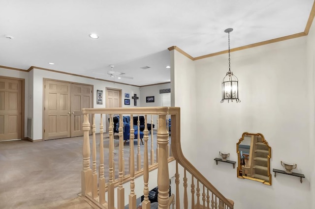 stairs featuring carpet flooring, ceiling fan with notable chandelier, and ornamental molding