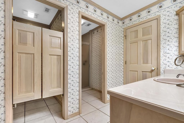 bathroom with tile patterned flooring, vanity, a shower with door, and ornamental molding