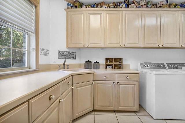 laundry area featuring cabinets, light tile patterned floors, sink, and washing machine and clothes dryer