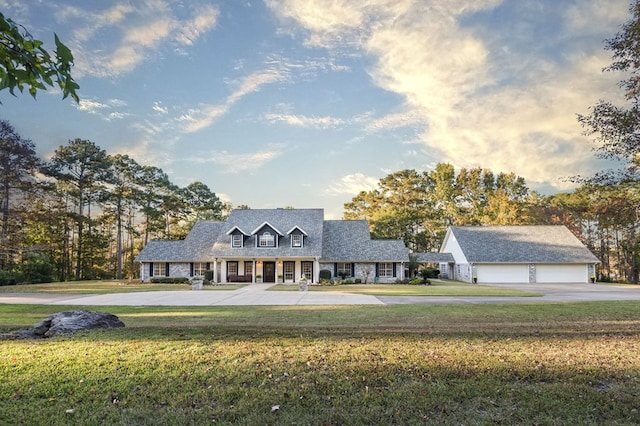 cape cod-style house with an outbuilding and a front yard