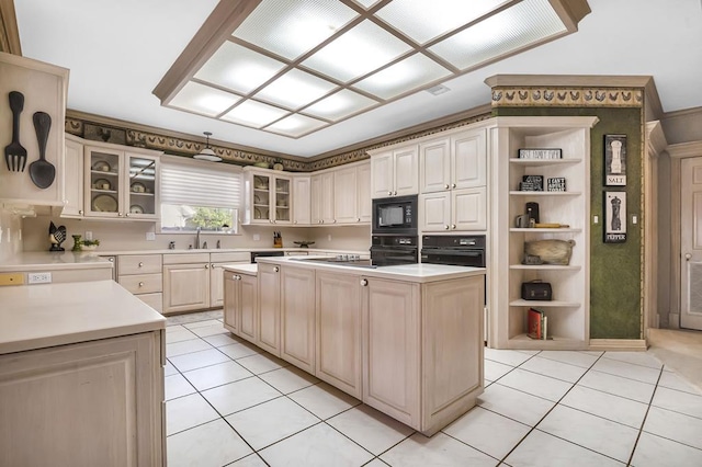 kitchen featuring light tile patterned flooring, sink, a kitchen island, and black appliances