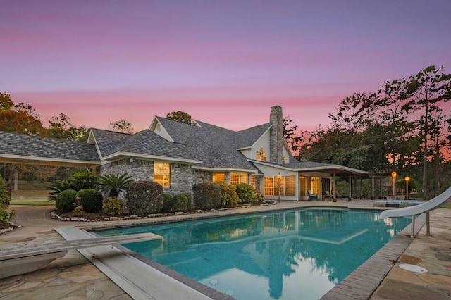 2101 Fm 1007, Brookeland, TX 75931 - pool at dusk with a patio area, a diving board, and a water slide