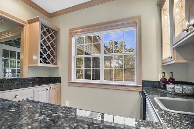 kitchen with ornamental molding and dark stone counters