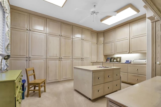 kitchen featuring cream cabinets, ceiling fan, a center island, and light colored carpet