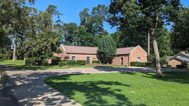 ranch-style house with a front yard and brick siding