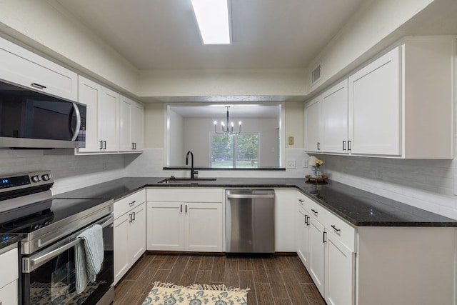 112 Westchester St, Lufkin, TX 75901 - kitchen featuring appliances with stainless steel finishes, a chandelier, white cabinets, and dark wood finished floors