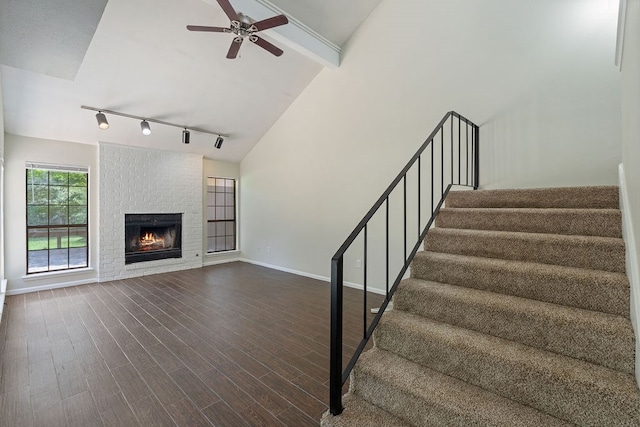112 Westchester St, Lufkin, TX 75901 - stairs with track lighting, a ceiling fan, a brick fireplace, and wood finished floors