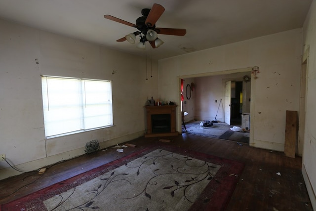 unfurnished living room with ceiling fan and dark wood-type flooring