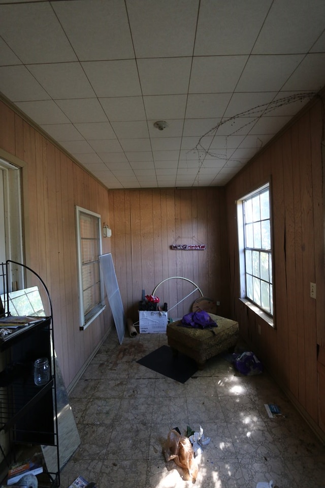 interior space with wood walls and a drop ceiling