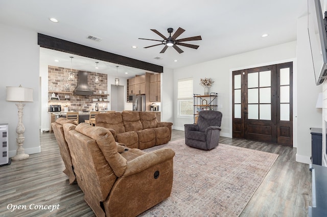 living area featuring recessed lighting, visible vents, baseboards, and wood finished floors