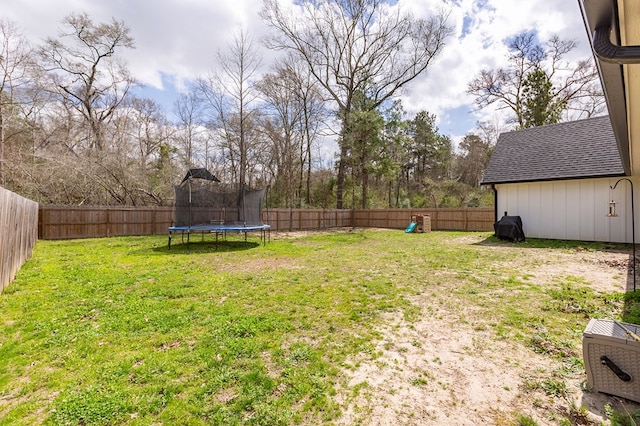 view of yard with a trampoline and a fenced backyard