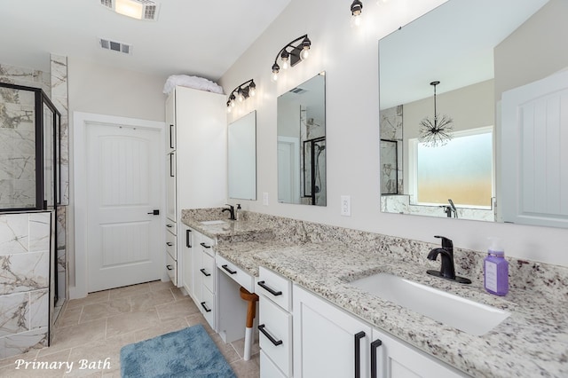 full bath with a marble finish shower, visible vents, and a sink