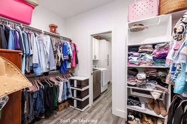 spacious closet featuring washer and dryer and wood finished floors