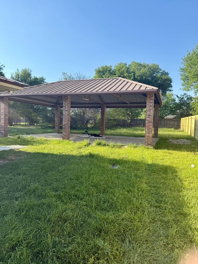 view of community with fence, a lawn, and a gazebo