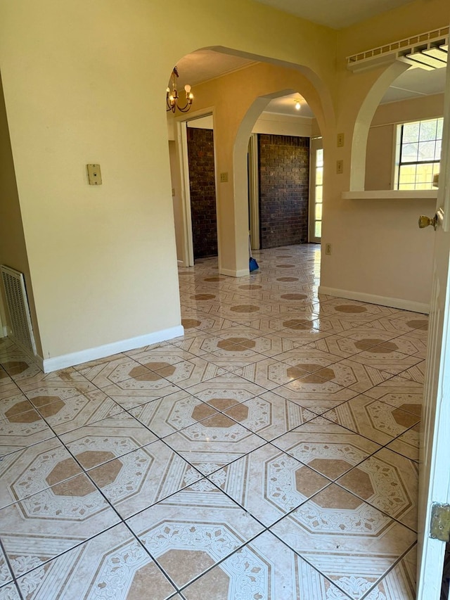 spare room featuring light tile patterned floors, arched walkways, an inviting chandelier, baseboards, and visible vents