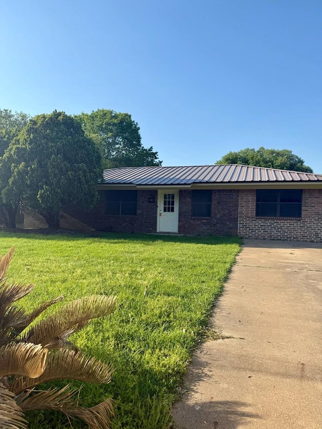 ranch-style house featuring brick siding and a front yard